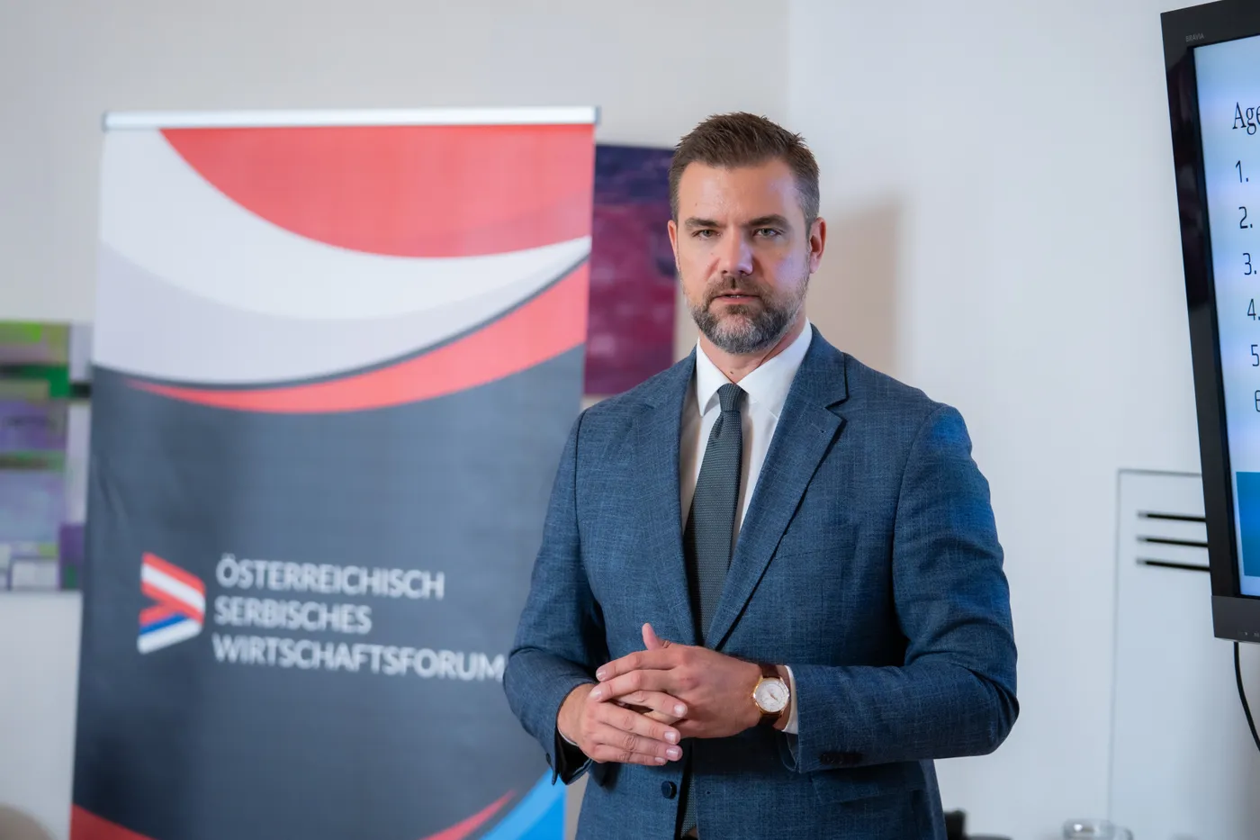 Der Vortragende neben dem Aufsteller des Österreichisch-Serbischen Wirtschaftsforums