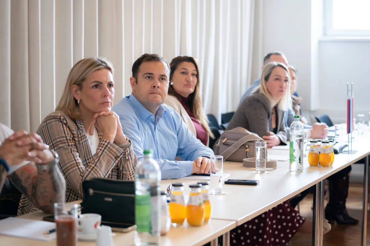 Teilnehmer entlang der langen Tafel beim Business Breakfast